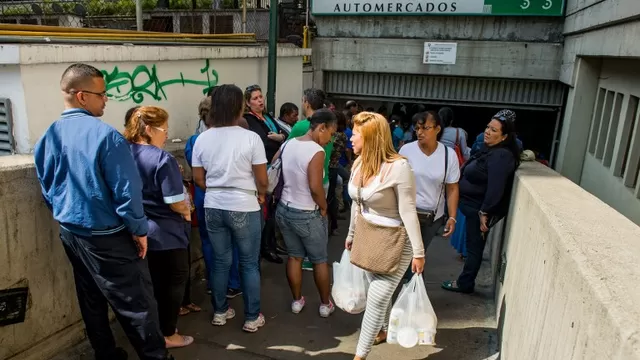 La gente hace cola en las afueras de un supermercado en Caracas. (V&iacute;a: AFP)