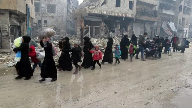 Los residentes sirios, huyendo de la violencia en el resistido barrio de Bustan al-Qasr, llegan al barrio de Fardos de Alepo el 13 de diciembre. (Vía: AFP)