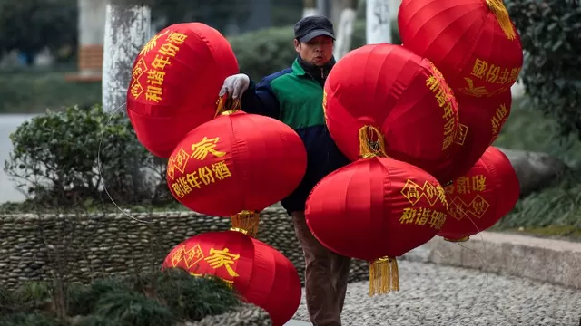 Un trabajador cargando globos de decoración. (Vía: AFP)