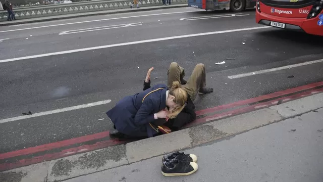 Una mujer atiende a una persona herida en el puente Westminster. (Vía: Toby Melville/Reuters)