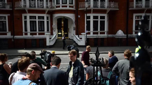 Polic&iacute;as y periodistas en frente de la casa de Julian Assange. (V&iacute;a: AFP)