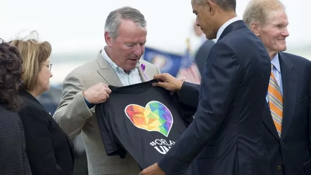 El alcalde de Orlando Buddy Dyer recibe una camiseta del presidente Obama por la tragedia ocurrida en el bar gay Pulse. (Vía: AFP)