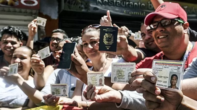 Venezolanos muestran sus cédulas y pasaportes. Foto: AFP