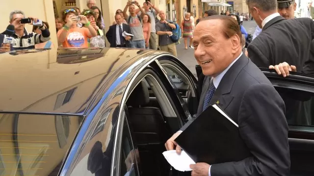   En la imagen se aprecia a Berlusconi abordando un vehículo luego de una conferencia de prensa