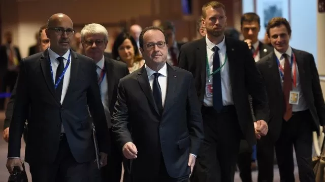 Presidente de Francia François Hollande camina junto a su delegación de asesores. (Vía: AFP)
