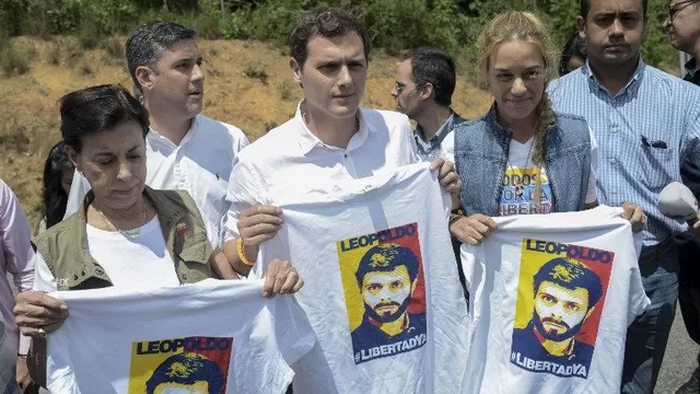 Lilian Tintori y simpatizantes sostienen polos con la cara de Leopoldo López. (Vía: AFP)