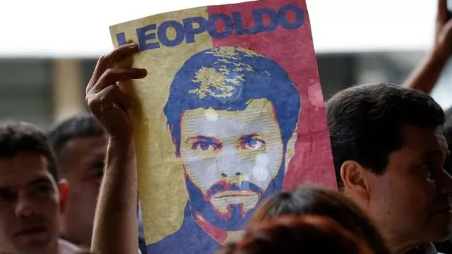 Una mujer sostiene el rostro pintado de Leopoldo López. (Vía: AFP)