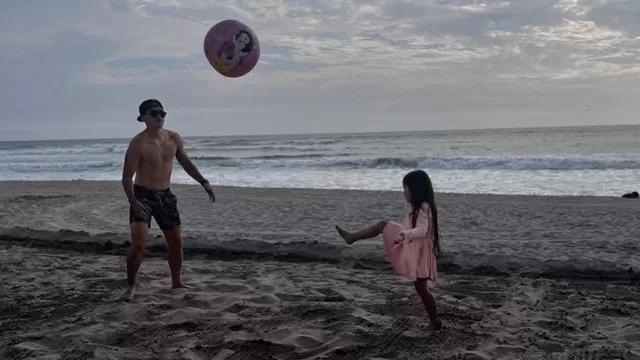 Rodrigo Cuba y su hija Mía juegan fútbol en la playa.