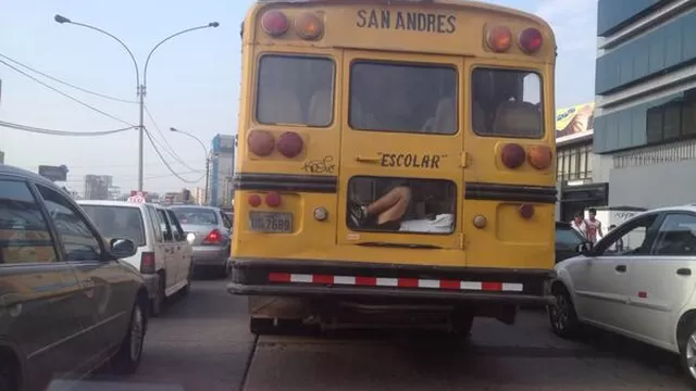 Niño viaja peligrosamente en la parte posterior de un bus escolar