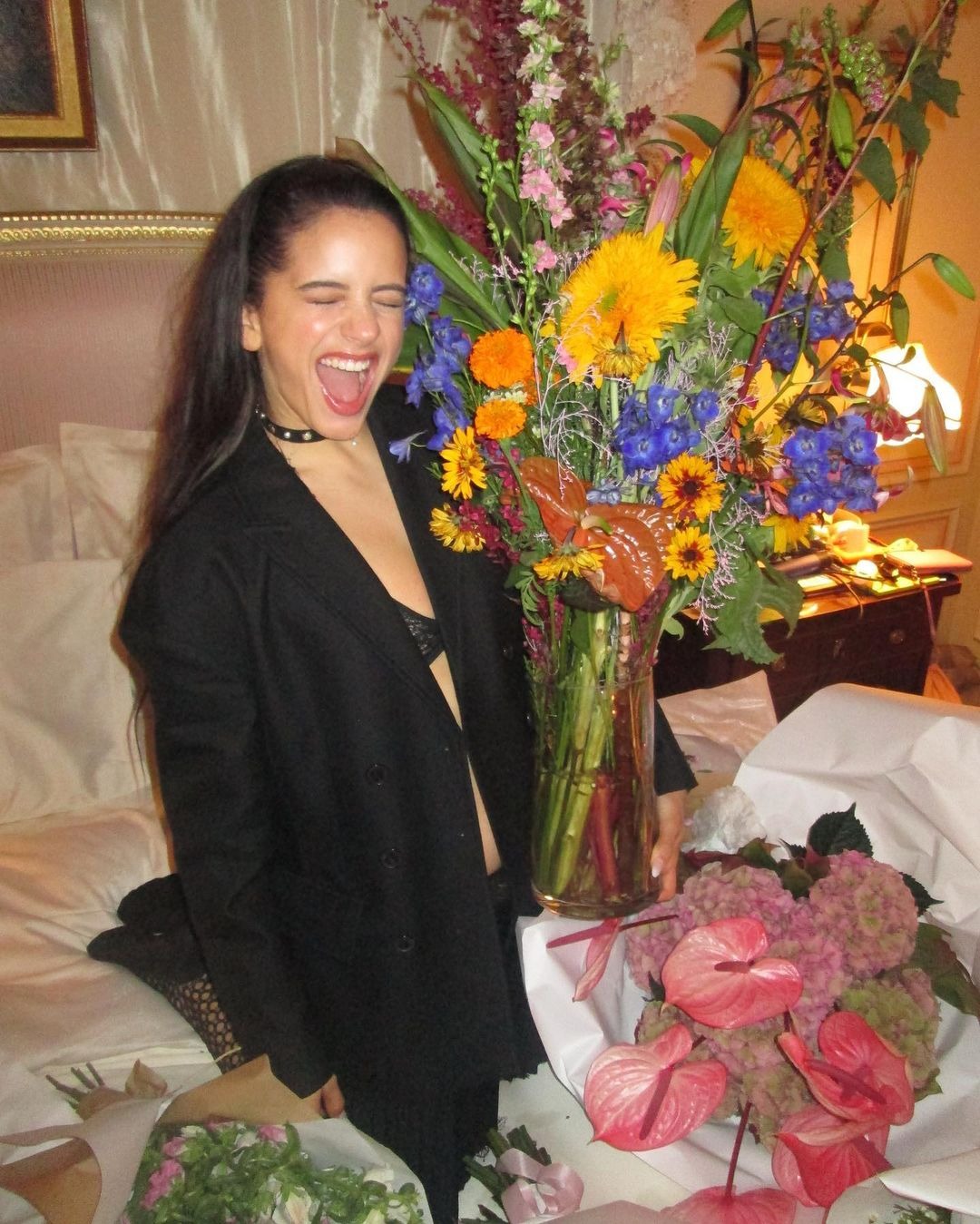 Rosalía posando feliz junto a las flores que abarrotaron su habitación de Hotel/ Foto: Instagram