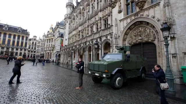 Gente posando frente a un veh&iacute;culo militar en La Grand-Place ubicada en el centro de Bruselas / Foto: AFP