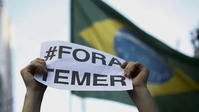 Simpatizantes de Dilma Rousseff sostienen carteles pidiendo la expulsión de Michel Temer. (Vía: AFP)