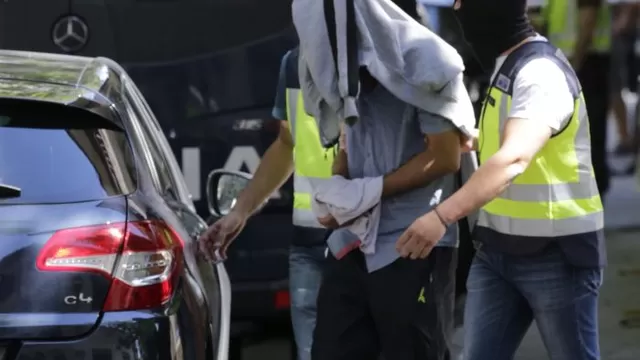   Agentes de la Policía Nacional conducen al detenido con la cabeza tapada, tras concluir el registro de la casa de este supuesto yihadista capturado en la localidad madrileña de San Martín de la Vega (Foto: EFE)