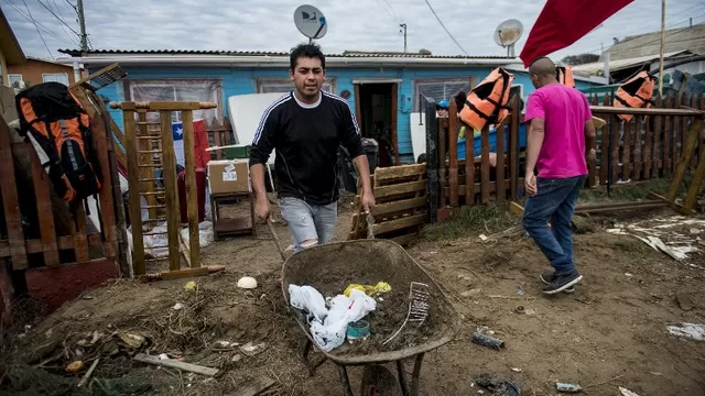 Residentes locales limpian sus hogares en Coquimbo. (V&iacute;a: AFP)