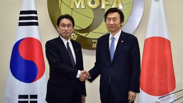 Ministro de Relaciones Exteriores de Corea del Sur le da la mano a su contraparte japonés. (Vía: AFP)