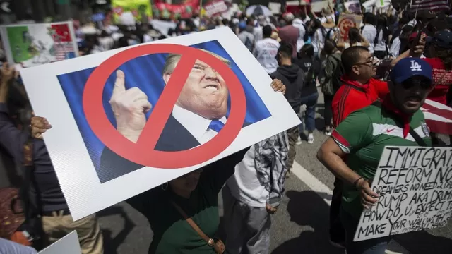 Una mujer carga una pancarta contra Donald Trump. (Vía: AFP)