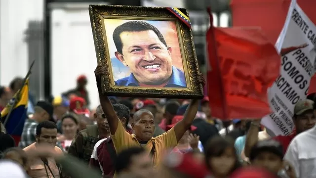 Imagen de Hugo Chávez cargada por sus simpatizantes. (Vía: AFP)
