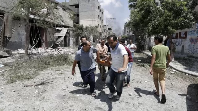 Palestinos evac&uacute;an una v&iacute;ctima durante una ofensiva repitente de la milicia israel&iacute; en Shiyaiya. 20/07/14. (Foto: AFP)
