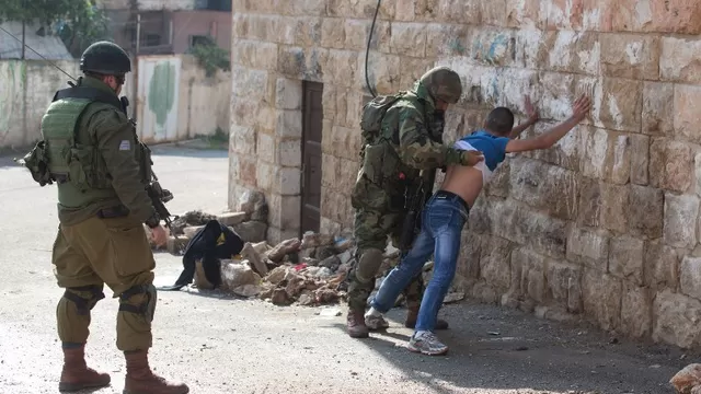 Soldados israel&iacute;es detienen a un joven palestino. (V&iacute;a: AFP)