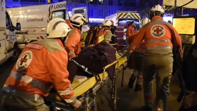   Trabajadores de la Cruz Roja rescatan a un herido cerca del teatro en donde ocurrió el atentado de ayer / Foto: AFP