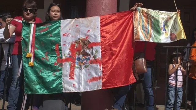 Activistas muestran una bandera de México con el número 43. (Vía: AFP)