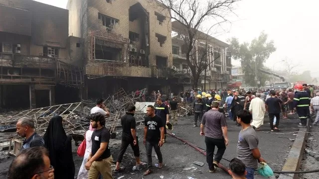 Iraquíes incluyendo bomberos se reúnen en el lugar donde el kamikaze explotó (Ví: AFP)