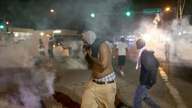 Manifestantes reaccionan ante bombas lacrim&oacute;genas lanzadas por la Polic&iacute;a. (Foto: The Washington Post)