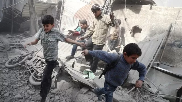 Niños sirios corren a esconderse tras los ataques aéreos del Gobierno en Douma. (Vía: AFP) 