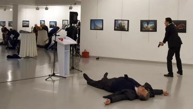 Andrey Karlov, el embajador ruso en Ankara, se encuentra en el suelo al lado de su asesino que sigue apuntando su arma a las personas que asisten a la exposición. (Vía: AFP)