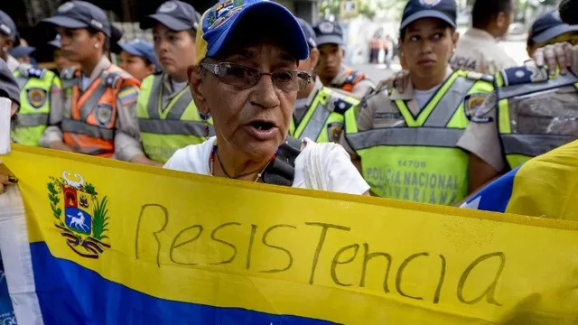 Un miembro de la oposición sostiene una bandera de Venezuela. (Vía: AFP)