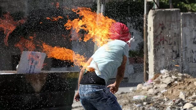 La ropa de un estudiante palestino se quema despu&eacute;s de que se prendiera en fuego al lanzar un c&oacute;ctel molotov a soldados israel&iacute;es. (V&iacute;a: AFP)